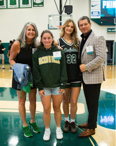Two students and their parents at the basketball court at JU