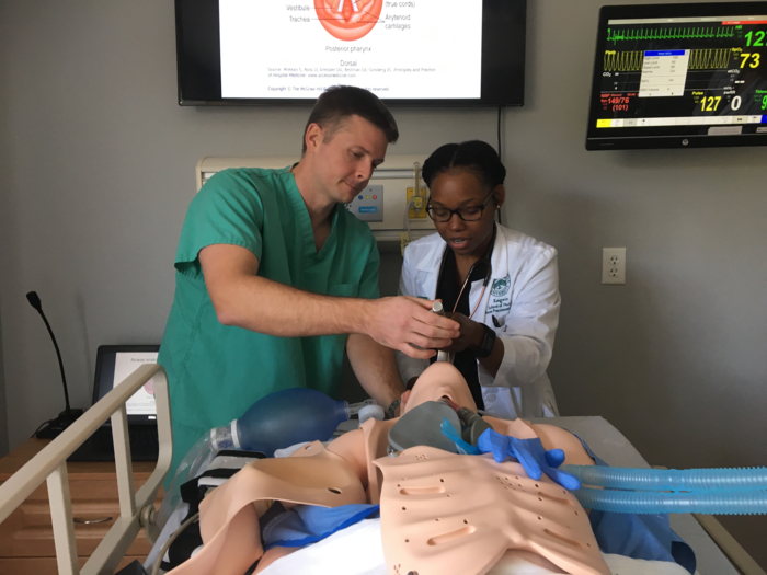 One male and one female nurse practice intubating a healthcare maniken