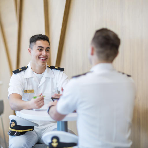 two navy students chatting at a table