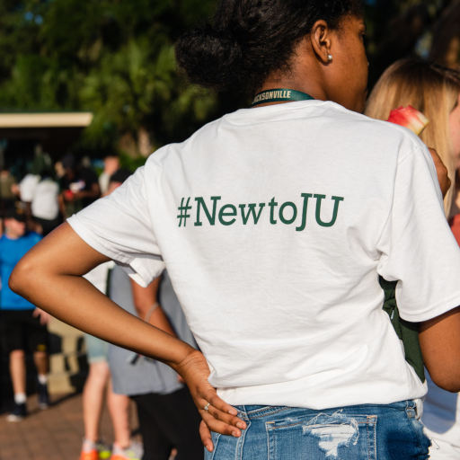 a student with their back to the photographer wearing a #NewtoJU t-shirt