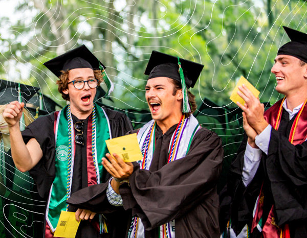 Students in graduation attire holding diplomas during a graduation ceremony