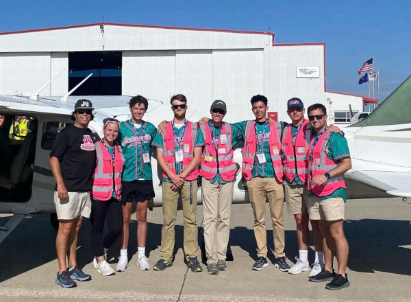 Aviation Student Organization showing young people standing in front of an airplane shed