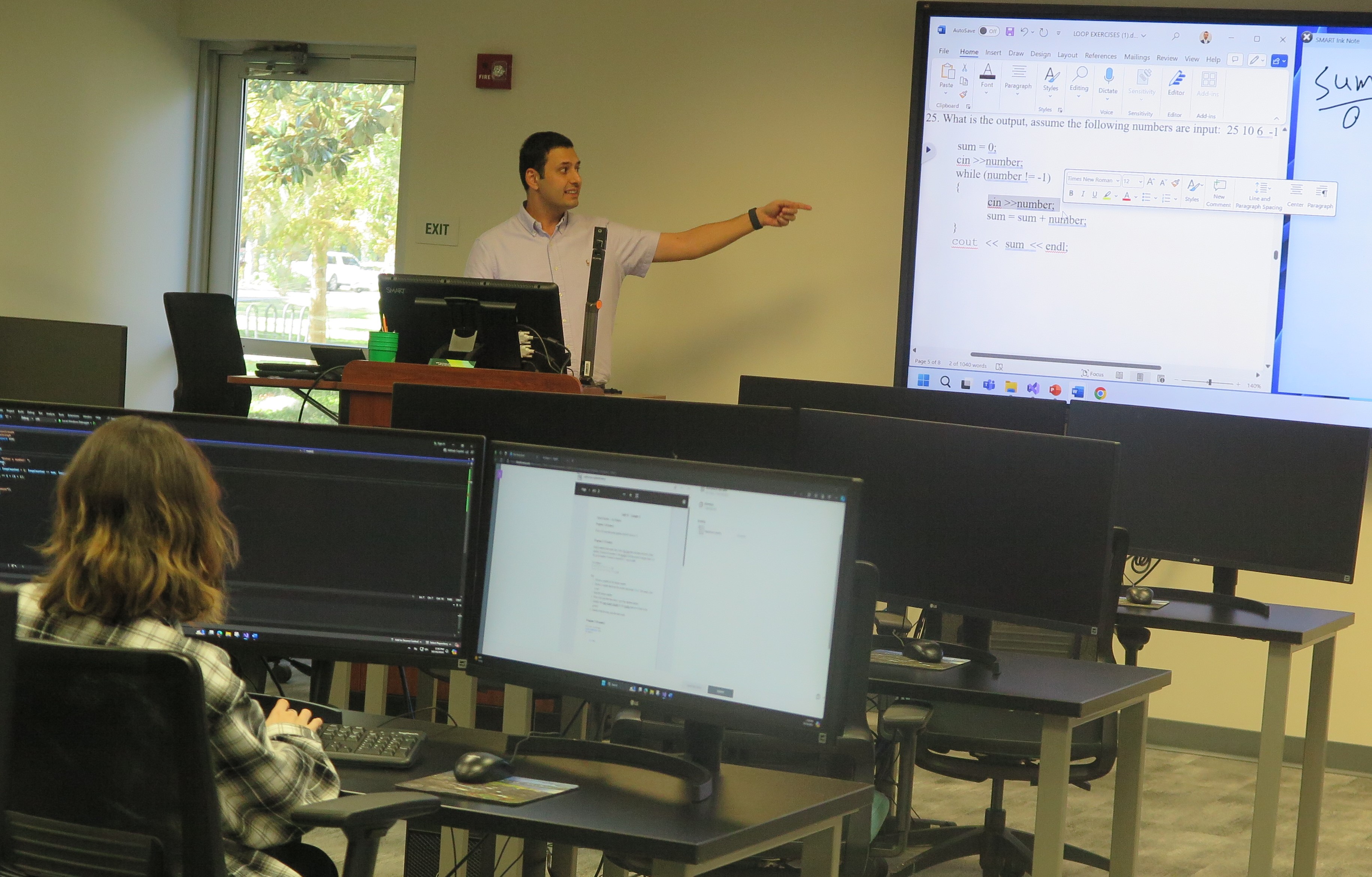 Student listening to the professor in a computer class.