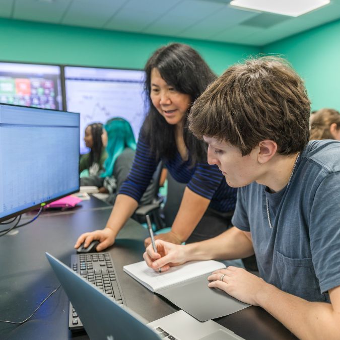 Student and teacher looking at computer screen