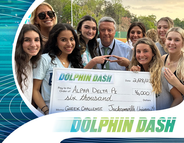 Students holding a scholarship check with President Cost at Dolphin Dash