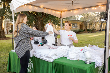 a group of people picking up swags at a swag table