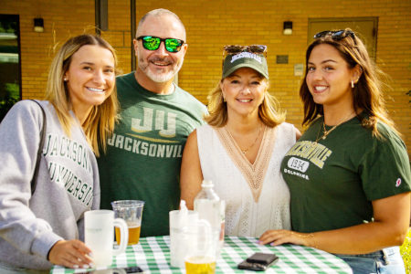 a family of four standing around a bar table smiling