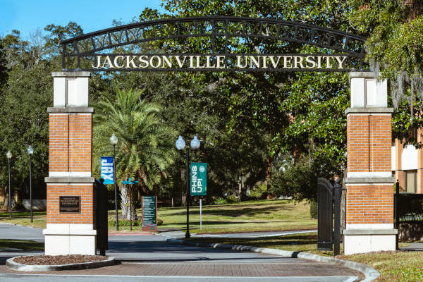 Two smiling Jacksonville University students wearing green