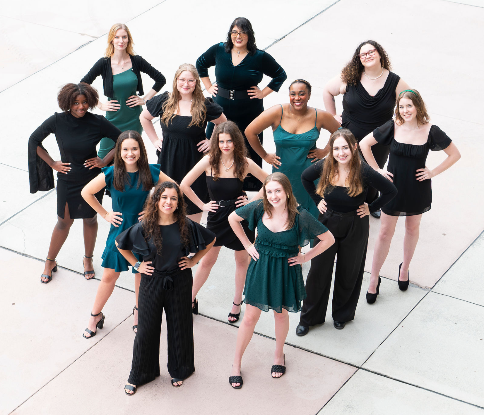 A dynamic group of young vocalists smiling at the camera on stage