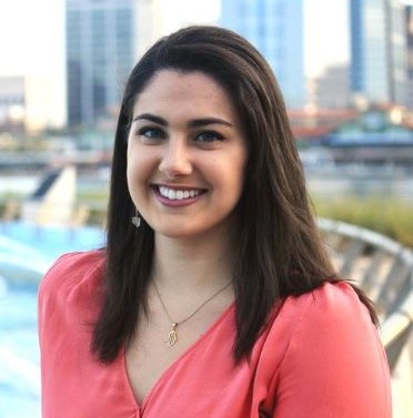 Hannah Shami smiling in front of the Jacksonville city skyline.
